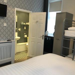 a bedroom with a bed and a bathroom with a shower at ParkRoyal Blackpool in Blackpool