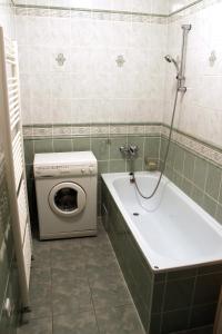 a bathroom with a washing machine and a bath tub at Apartmán TRIGA in Snina