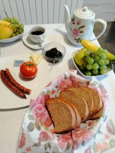 a table with a loaf of bread and a plate of fruit at Agropensiunea Ozon in Piatra Neamţ
