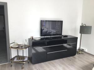 a black dresser with a television on top of it at Appartement Wissembourg hyper centre in Wissembourg