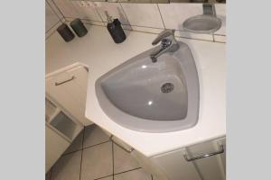 a white bathroom sink with a faucet at Ferienwohnung Kalldorf in Kalletal