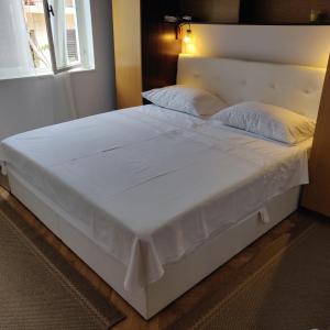 duże białe łóżko w pokoju z oknem w obiekcie Apartment Zorić Grebaštica w mieście Grebaštica