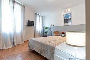 - une chambre blanche avec un lit et une fenêtre dans l'établissement Marinali Rooms, à Bassano del Grappa