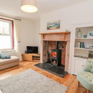 a living room with a fireplace and a couch at Cheviot Way Cottage in Wooler