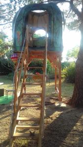 a tree house on a ladder under a tree at Nuit insolite in Vias