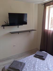 a bedroom with a tv and two towels on a bed at Black Sea treasure in Varna City