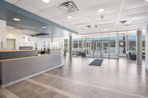 an office lobby with a reception counter and windows at Residence & Conference Centre - Niagara-on-the-Lake in Niagara on the Lake