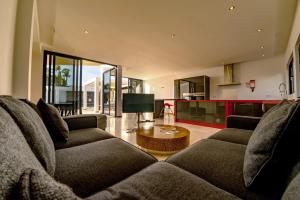 a living room with two couches and a table at Casa Chani with heated pool in El Roque in Cotillo