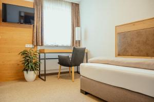 a hotel room with a bed and a desk at Kondrauer Hof in Waldsassen