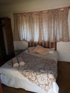 Greenhill Chalets Grootfontein في Grootfontein: غرفة نوم بسرير كبير مع نافذة