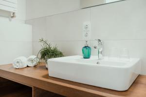 a bathroom with a white sink on a wooden counter at Kondrauer Hof in Waldsassen