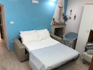 1 dormitorio con cama y pared azul en Cottage Azzurra, en Ischitella