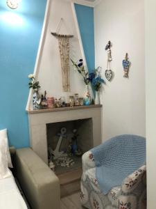 ein Wohnzimmer mit einem Kamin und einem Stuhl in der Unterkunft Cottage Azzurra in Ischitella
