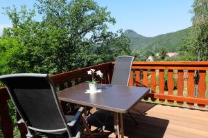 ein Tisch und zwei Stühle auf einer Terrasse mit Bergen in der Unterkunft Elbblick in Prossen