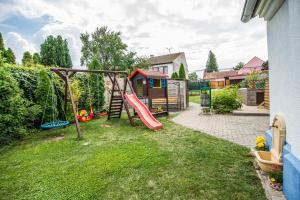 un patio trasero con un parque infantil con un tobogán en Malovaný dvůr en Dolní Dunajovice