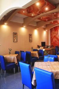 B&B Vila Tamaris في زاييتشار: مطعم بطاولات وكراسي زرقاء وبار