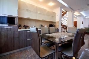 a kitchen and dining room with a table and chairs at Casa cu Flori Moisei in Moisei