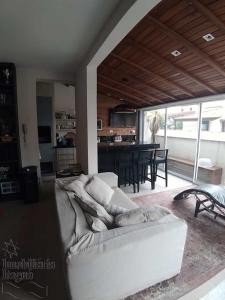 uma sala de estar com um sofá branco e uma mesa em Cobertura Duplex Praia Grande Ubatuba em Ubatuba