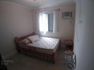 um pequeno quarto com uma cama e uma janela em Cobertura Duplex Praia Grande Ubatuba em Ubatuba