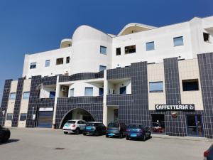 a building with cars parked in front of it at La Maison Latina Guest House in Latina