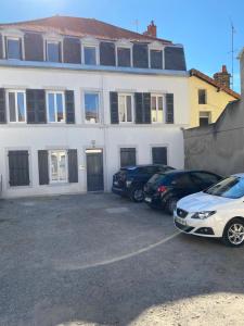 une maison blanche avec des voitures garées devant elle dans l'établissement La Bâtisse de Chabot n°8, à Montluçon