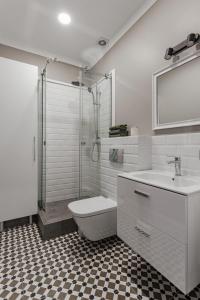 a bathroom with a shower and a toilet and a sink at City Centre Silver Apartment in Odesa