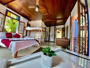a bedroom with two bunk beds and a table at Vila Pequeá Ilhabela in Ilhabela