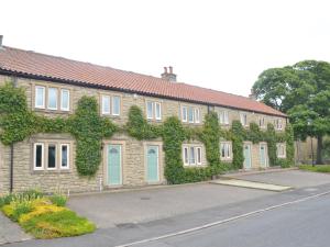 a building with ivy growing on the side of it at Plawsworth Hall Serviced Cottages and Apartments in Durham