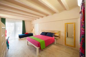 - une chambre avec un lit coloré et un miroir dans l'établissement Villa Bruno, à Maruggio