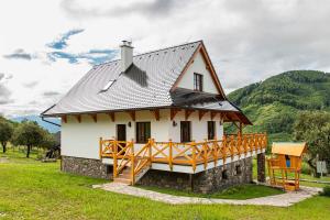 a house in a field with mountains in the background at Chata VČELÁRIK in Nová Baňa