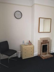 a room with a chair and a fireplace and a clock at Blackburn - Great prices, best rooms, nice place ! in Blackburn