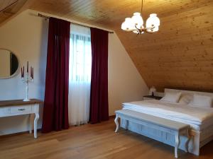 een slaapkamer met een groot bed met rode gordijnen bij Chata VČELÁRIK in Nová Baňa