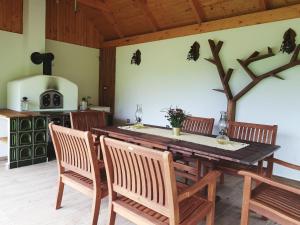 a dining room with a wooden table and chairs at Chata VČELÁRIK in Nová Baňa