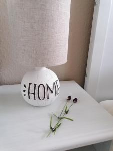 a vase with the word home on a table with flowers at Pension Mien Fründt in Baabe