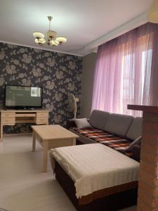 a living room with a couch and a tv at Vyshyvanka in the city centre in Ivano-Frankivsk