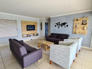 a living room with two couches and a table at 33 Kingston Place, Marina Martinique in Jeffreys Bay