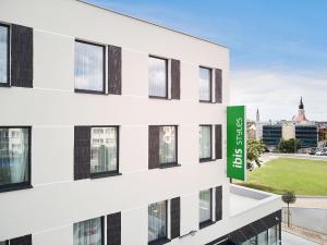 a building with a green sign on the side of it at ibis styles Bolesławiec in Bolesławiec