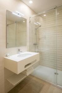 a bathroom with a white sink and a shower at Clube Porto Mos - Sunplace Hotels & Beach Resort in Lagos