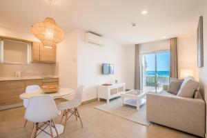 a kitchen and living room with a table and a couch at Clube Porto Mos - Sunplace Hotels & Beach Resort in Lagos