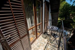 a balcony with a table and a glass door at Apartmani Sunčev breg Vlasinsko jezero in Surdulica