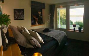 a bedroom with a bed with pillows and a window at Lovely studio apartment seaview & private sauna in Lerum