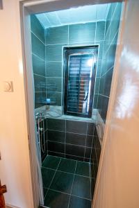 a bathroom with a shower with a mirror at Apartmani Sunčev breg Vlasinsko jezero in Surdulica
