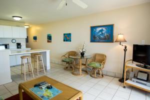 a living room with a table and a kitchen at Hale Kai O'Kihei 120 in Kihei