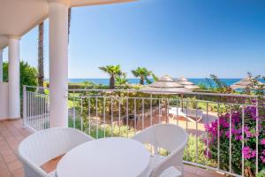 einen Balkon mit einem Tisch, Stühlen und Meerblick in der Unterkunft Clube Porto Mos - Sunplace Hotels & Beach Resort in Lagos