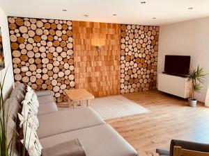 een woonkamer met een bank en een muur van houtblokken bij Ferienwohnung Bad Camberg - Apartment 3 Hoelzer in Bad Camberg