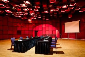 a conference room with tables and chairs and red walls at Hotel Thermal in Karlovy Vary +30 photos