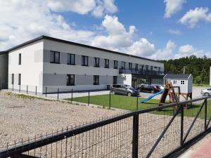 a white building with a playground in front of it at Wielobranżówka in Szepietowo