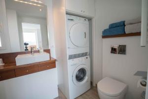 a bathroom with a washing machine and a sink at Penthouse Cortey in Calella de Palafrugell