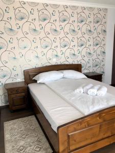 a bed with two towels on it in a bedroom at Conacul Lupilor in Satu Şugatag