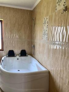 y baño con bañera y 2 sillas. en Conacul Lupilor, en Satu Şugatag